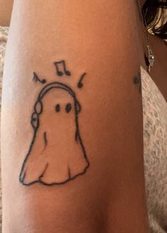 a woman's arm with a drawing of a ghost listening to music