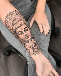 a woman's arm with a buddha tattoo on it