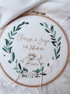 a wedding embroidered on a white hoop with flowers and greenery around the hoop that reads, cross & jove