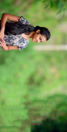 a woman standing in the grass with her hands on her hips