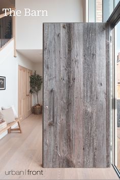 an open door in the middle of a living room with wood floors and white walls