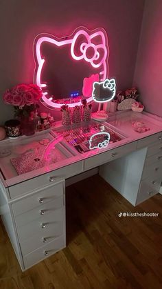 a desk with a hello kitty neon sign on it