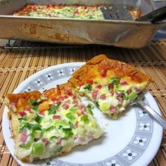 two slices of pizza sitting on top of a white plate next to a silver pan