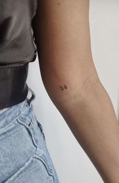 a woman's arm with a small tattoo on the left side of her arm