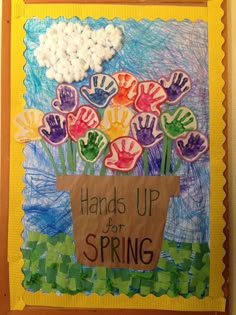 an art project with handprints and flowers in a box on the wall,