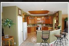 a kitchen with an island and bar stools in the center, surrounded by wooden cabinets