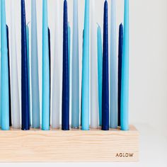 blue and white candles are lined up on a wooden stand