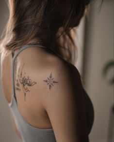 a woman with a small tattoo on her back shoulder and arm is looking at the camera