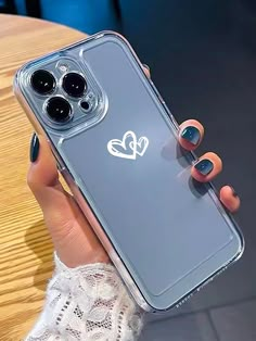 a woman holding an iphone case with two hearts on it