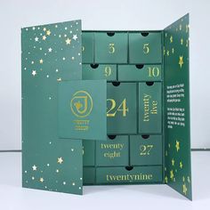 an open green box with gold numbers and stars on the inside, in front of a white background