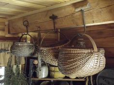 two wicker baskets hanging from hooks on a shelf in a room with wood paneling