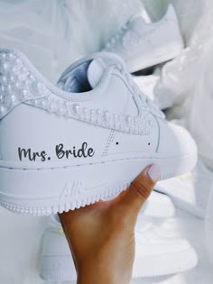 a person holding up a white shoe with the word mrs bride written on it