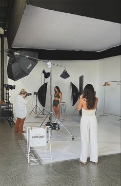 three women standing in front of photography equipment