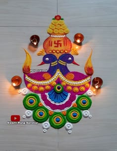 a decorated diya with candles on the floor