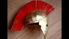 a helmet made out of cardboard sitting on top of a wooden floor