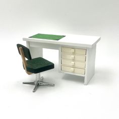 a white desk with a green chair next to it