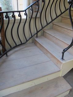 a set of stairs with handrails next to a window in a home's entryway