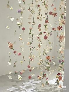 an art installation with flowers hanging from the ceiling