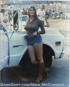 a woman standing next to a white truck