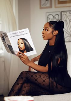 a woman sitting on a couch reading a magazine