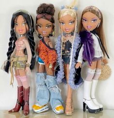 four dolls are standing next to each other