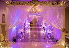 the entrance to a wedding venue decorated in purple and white colors with chandelier