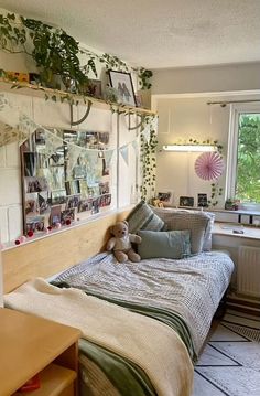 a bedroom with a bed, desk and pictures hanging on the wall above it's headboard