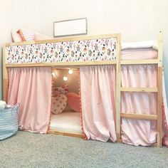 there is a bunk bed with pink curtains on it