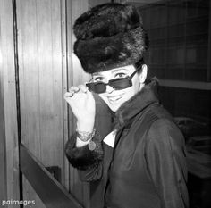 a woman wearing sunglasses and a fur hat