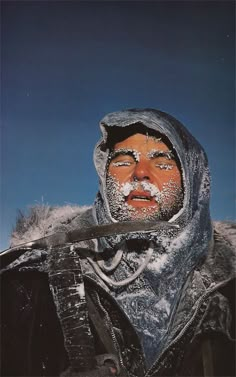 a man with snow on his face holding a knife