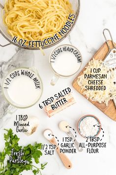 ingredients needed to make creamy pasta on a marble counter top with measuring spoons, parmesan cheese and fresh parsley