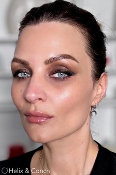 a close up of a woman with makeup on her face and eyeliners in the background