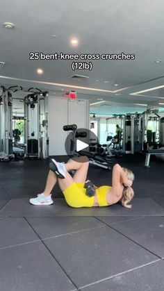 a woman laying on the ground in front of a gym machine with her back to the camera