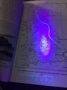 an open book with a purple light on it