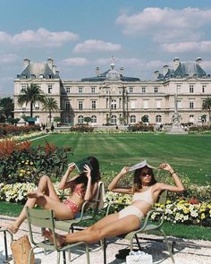 two women in bikinis lounging on lawn chairs