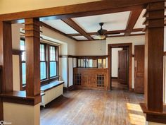 an empty living room with wood trimming and wooden flooring on the far wall