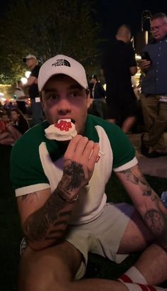 a man sitting on the ground eating food