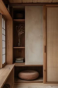 an empty room with wooden shelves and drawers, including a large round cushion on the floor