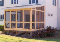 a large white house with lots of windows on it's sides and covered porch