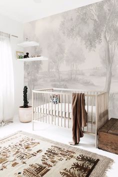 a baby's room with a crib, rug and wallpaper on the walls