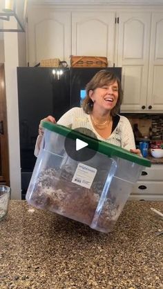 a woman holding a plastic container with food in it on top of a kitchen counter