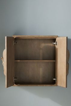 an empty wooden shelf with two shelves on each side and one door open to show the inside