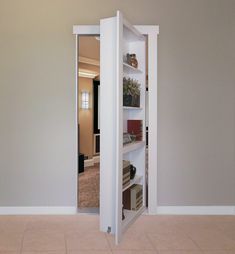 an open door in the middle of a room with white walls and tile flooring