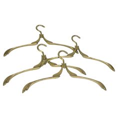 four brass metal hangers with leaves on each one side and three smaller ones in the middle