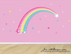 a pink wall with stars and a rainbow painted on it's side in front of a wooden floor