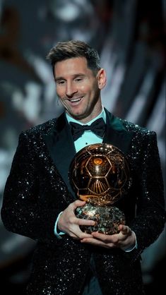 a man in a tuxedo holding an award