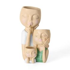 a ceramic figurine of two people holding a baby and an adult sitting next to it