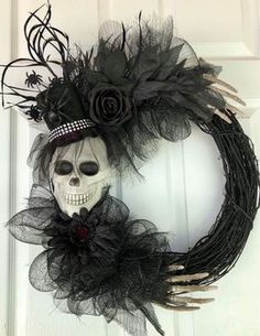 a wreath decorated with black feathers and a skull