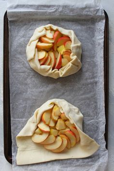 two apple pies sitting on top of a baking sheet