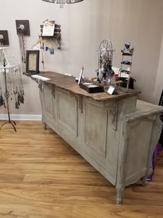 an old wooden desk in the middle of a room with jewelry on display and other items